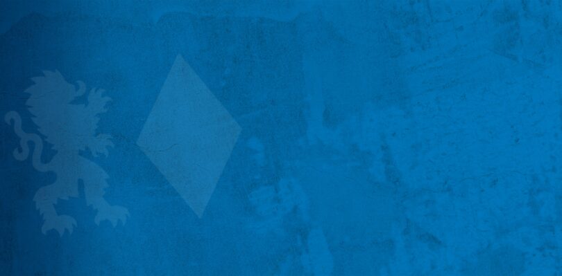 Eine mittelblaue fleckige Wand mit Rissen. Drauf als Wasserzeichen das Emblem der CSU, bestehend aus Löwen und Raute.