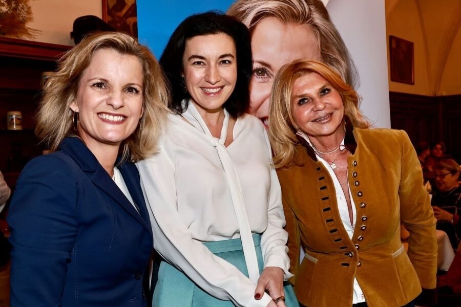 Daniela Ludwig, Dorothee Bär und Marisa Steegmüller stehen vor einem CSU-Plakat.